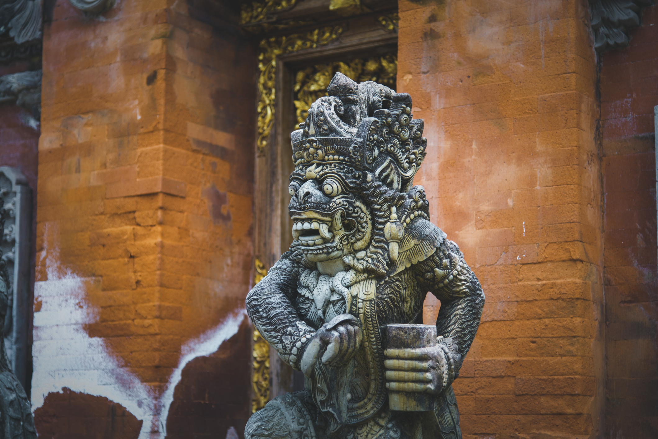 Indonesisch traditioneel standbeeld met oranje muur op de achtergrond
