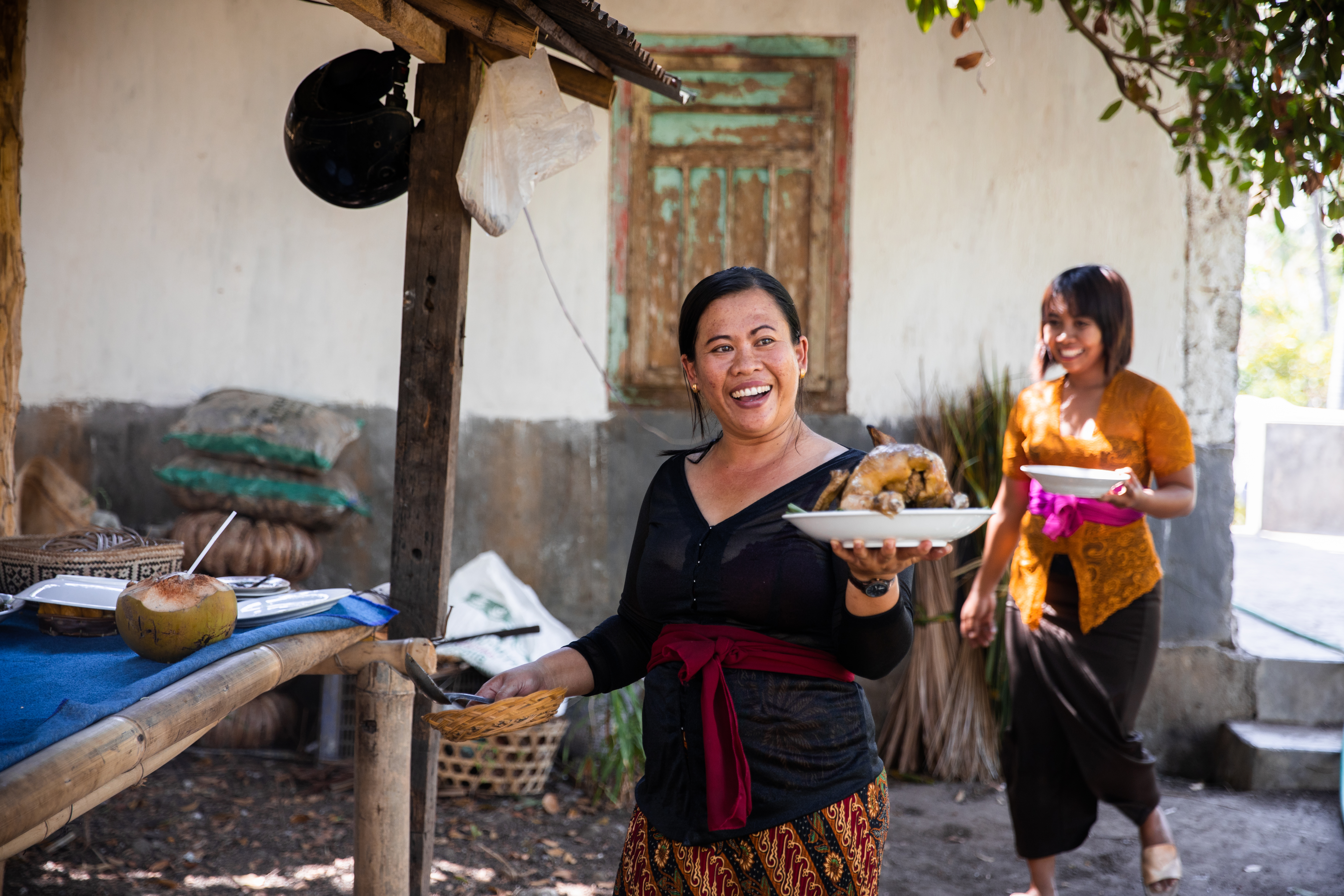 Indonesische vrouw die de kip toont die ze bereid heeft